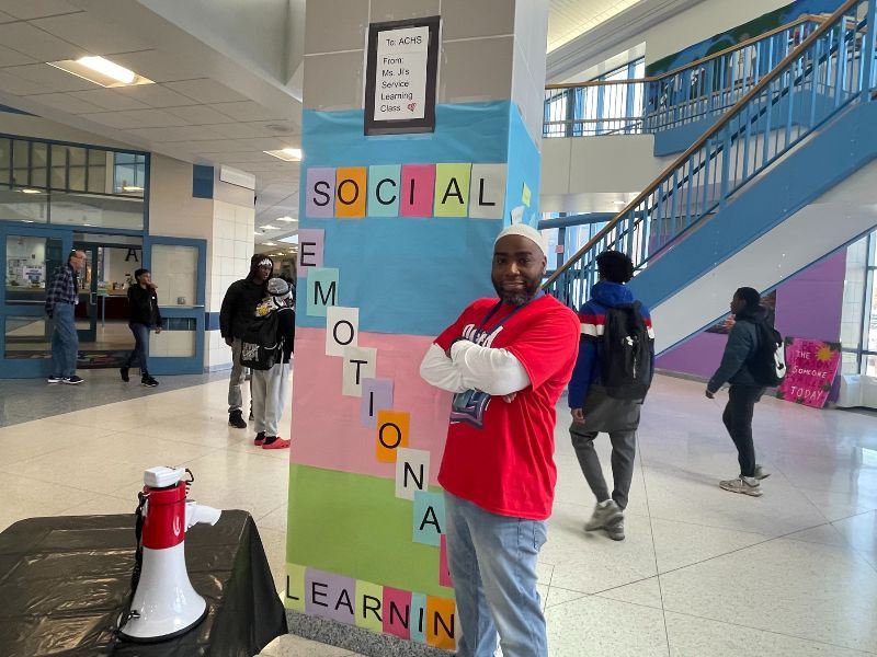 Atlantic City High School SEL Coach Thomas Kelly poses by SEL sign.